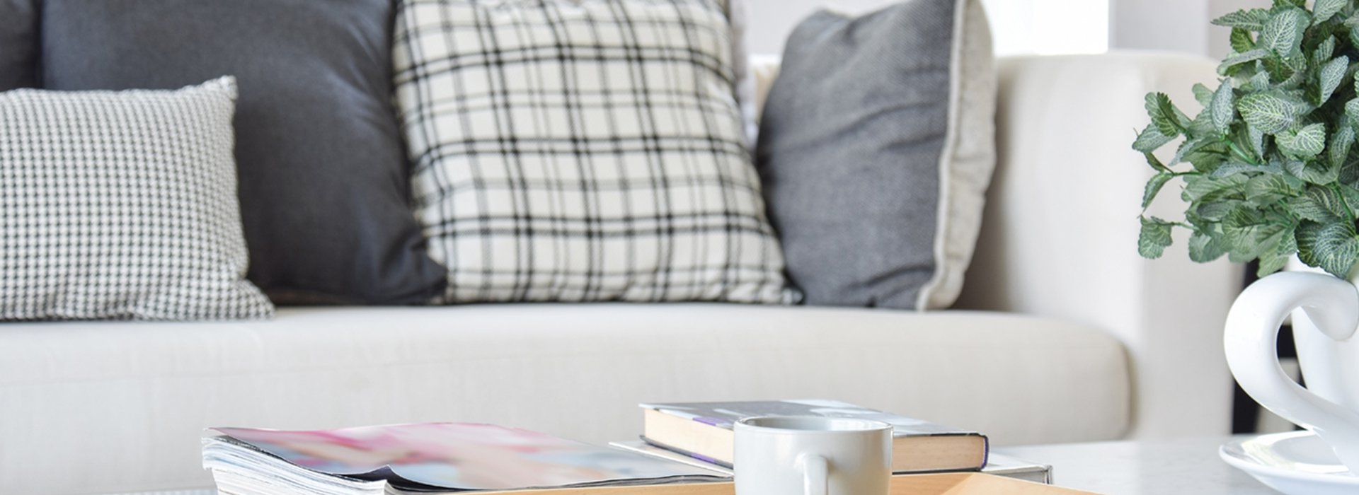 decorative wooden tray with tea cup and books in modern living room interior